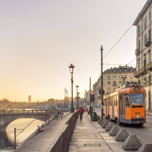 Turin, Italy. February, 15, 2022. View at sunset on the Po river In the distance the ancient Vittorio Emanuele I bridge and a tram passing in Lungo Po Luigi Cadorna street. Banner header.